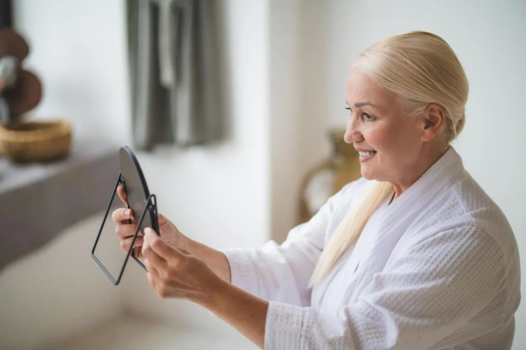 Mid aged pretty woman looking at the mirror