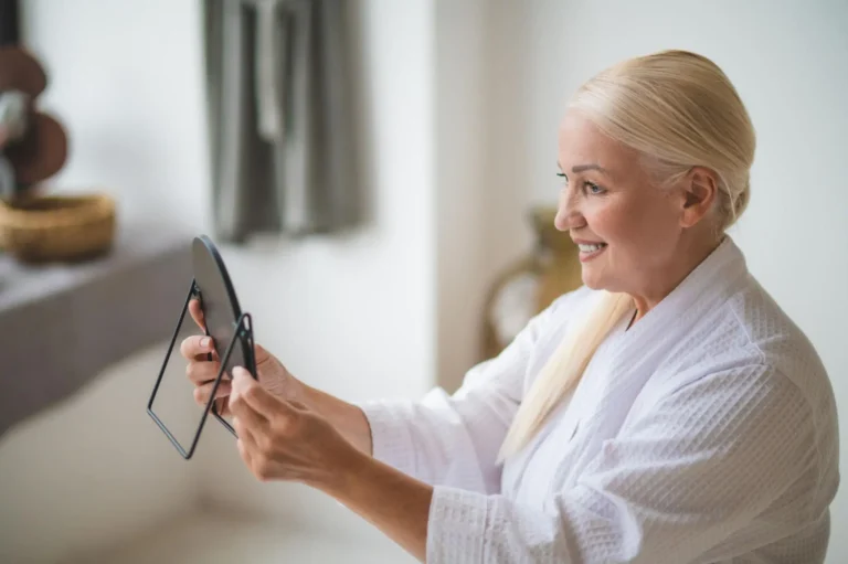 Mid aged pretty woman looking at the mirror